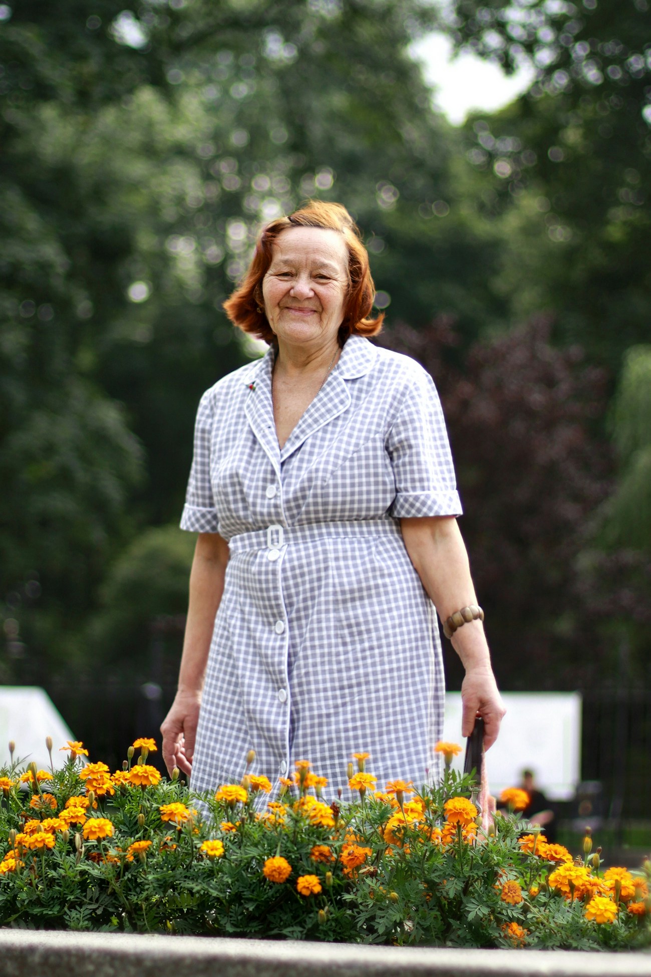 Senhora sorrindo em um jardim florido